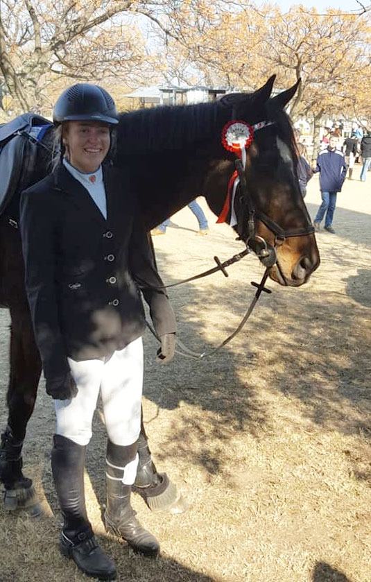 Rider in show jacket with her horse